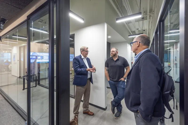 Three of the team talking in the corridor