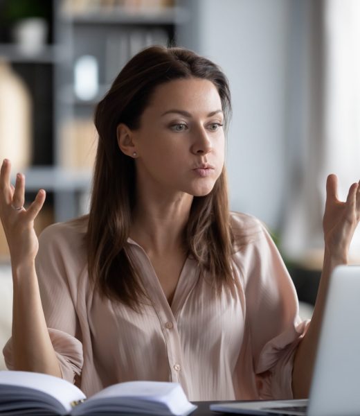 Unhappy young woman irritated by gadget work, low internet connection. Unhappy young woman looking at laptop screen, irritated by bad gadget work, low internet connection, working remotely at home. Stressed attractive lady annoyed by hard work task or system crash.